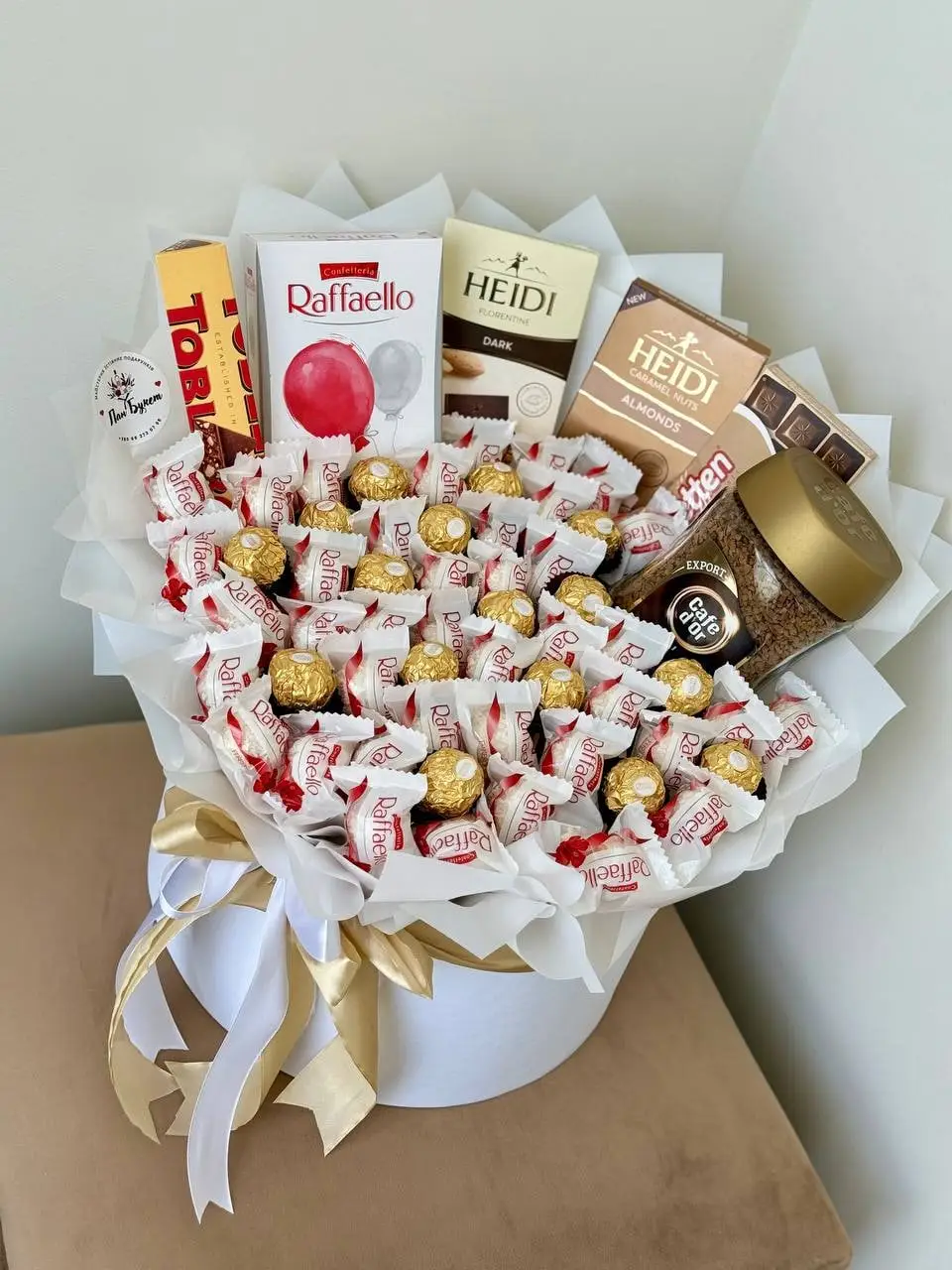 Біла коробка, наповнена цукерками Raffaello, Ferrero Rocher і шоколадом Heidi