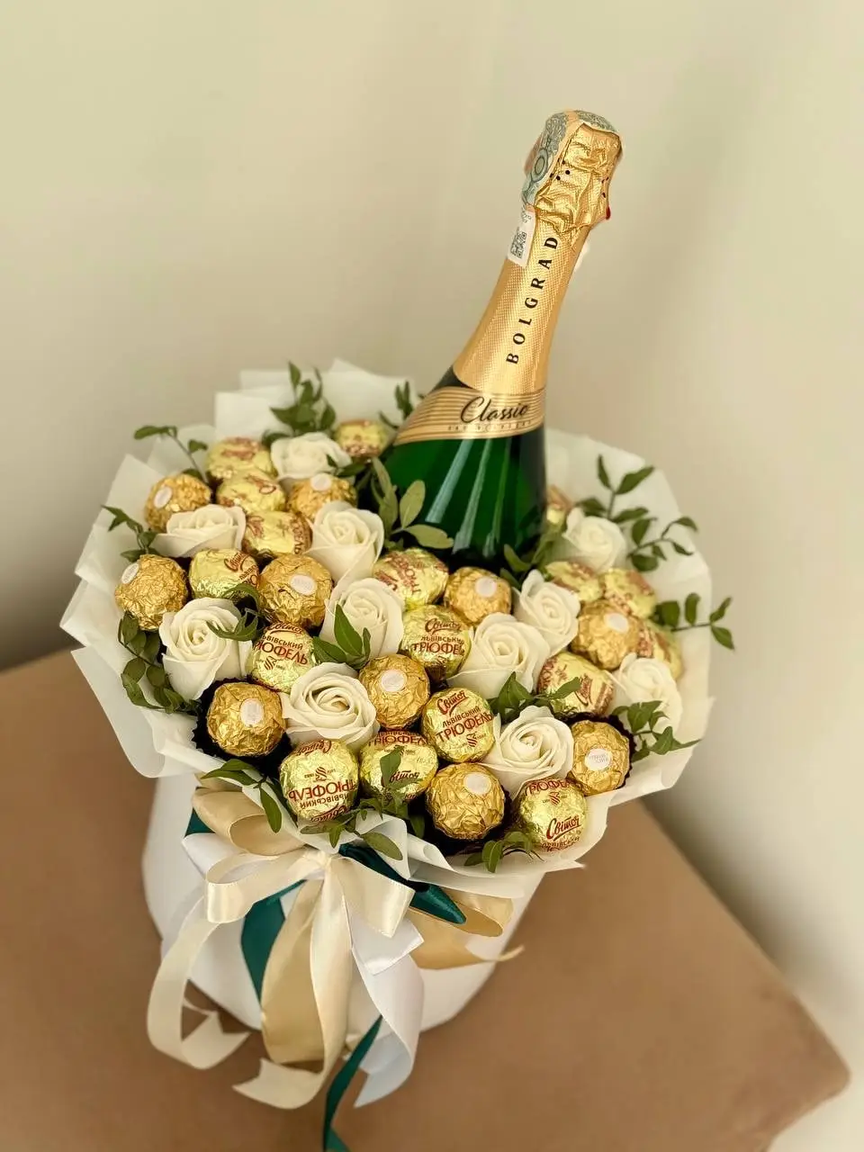 Композиція з пляшкою ігристого, білими трояндами та цукерками Ferrero Rocher