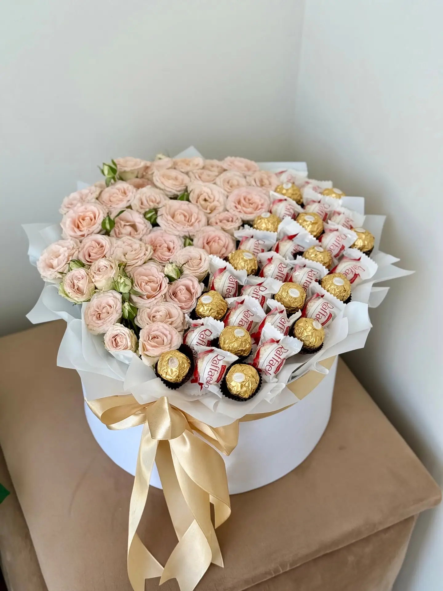 Букет із ніжно-рожевих кущових троянд, цукерок Ferrero Rocher і Raffaello у білій капелюшній коробці
